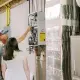 technician showing inside of tankless water heater to customer in basement.